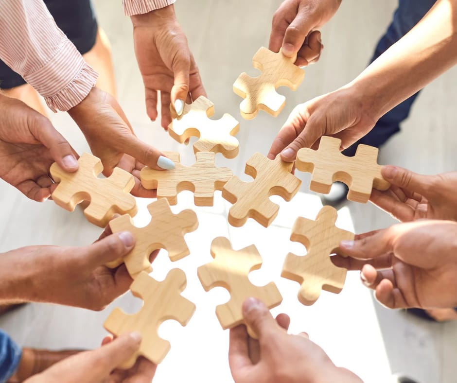 Imagen de un grupo de manos sosteniendo piezas de rompecabezas
